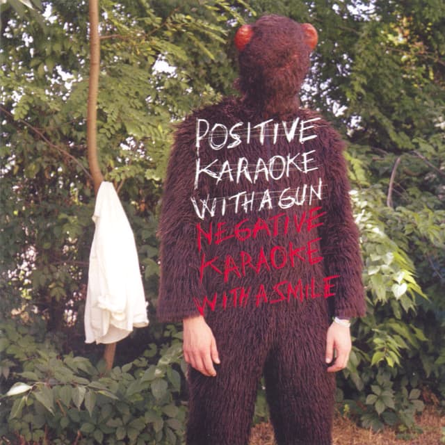 Album cover art for Positive Karaoke With A Gun - Negative Karaoke With A Smile